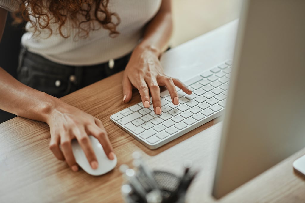 woman on the computer with her hand on the mouse and keyboard | Generator Repair Myrtle Beach, SC