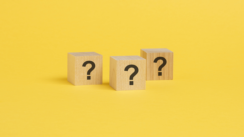 front view on many wood cubes with black question marks. many question arising concept. trouble and confusion. yellow background. backup generator