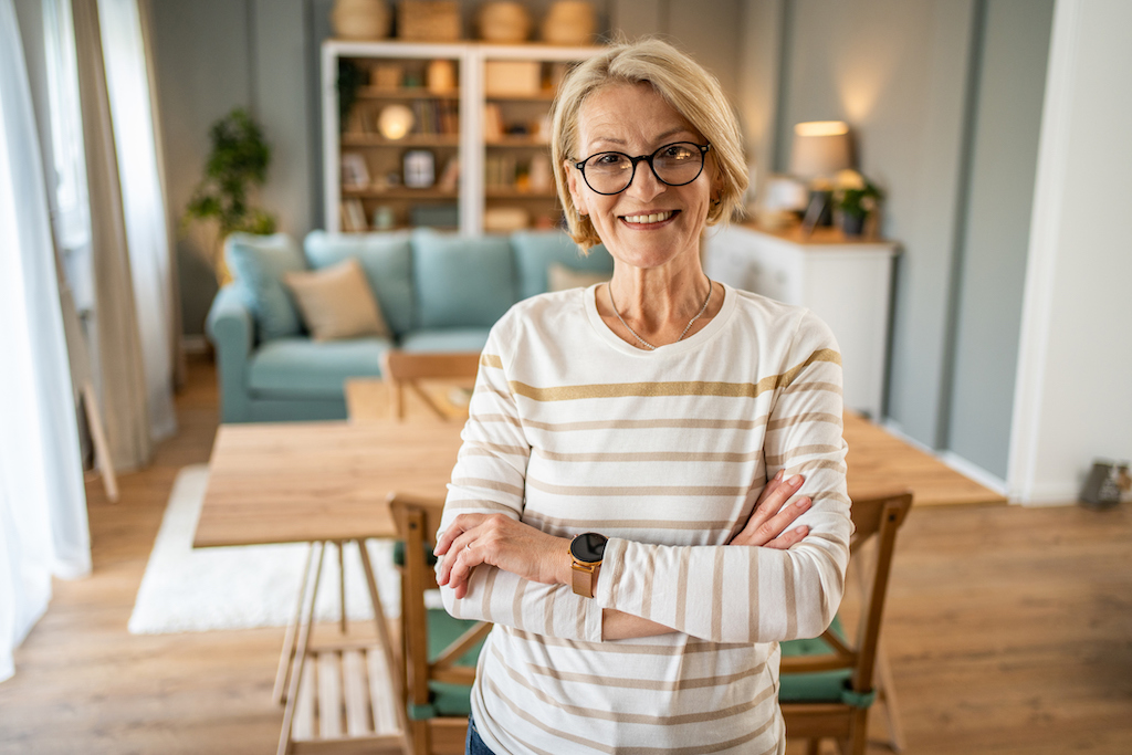Happy woman in her home with working lights and electricity thanks to her backup generator installation.