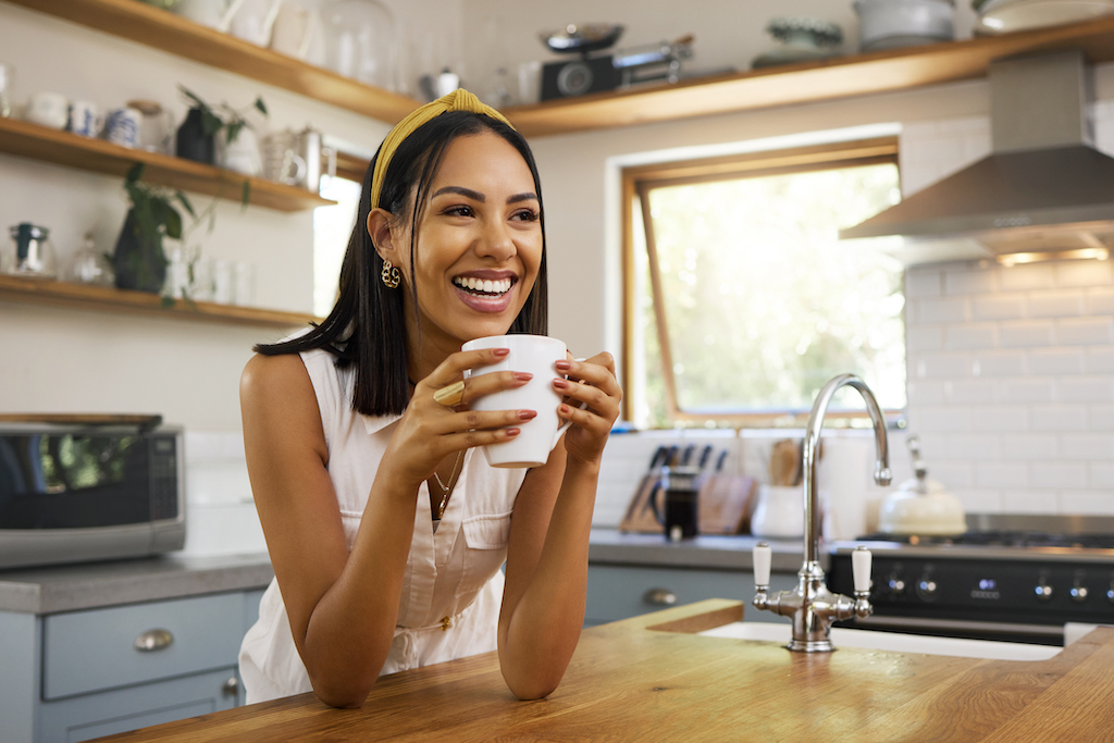 Photo of a woman in her kitchen with lights and power thanks to backup generator repair.