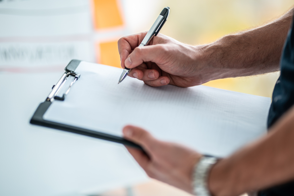 A man writing a comprehensive maintenance plan for a standby generator. | Generator Maintenance Service